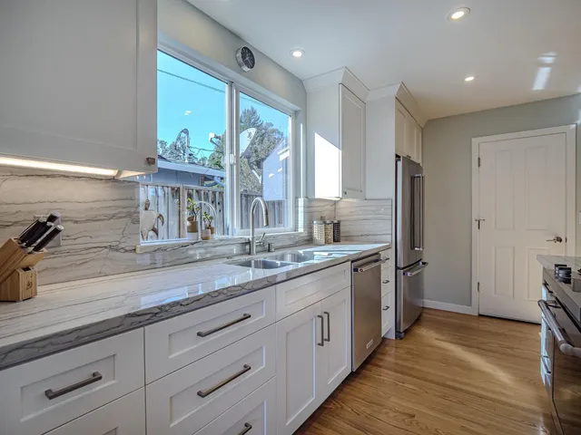 a bathroom with a granite countertop sink mirror and a shower