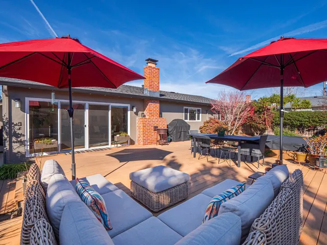 a view of a house with backyard sitting area and furniture
