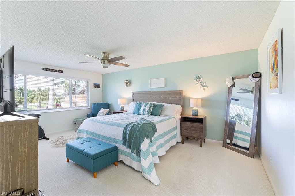 159 Quails Nest Road, Unit 1084 Naples, FL 34112 - Photo 13 of 21 a spacious bedroom with a bed and a large window