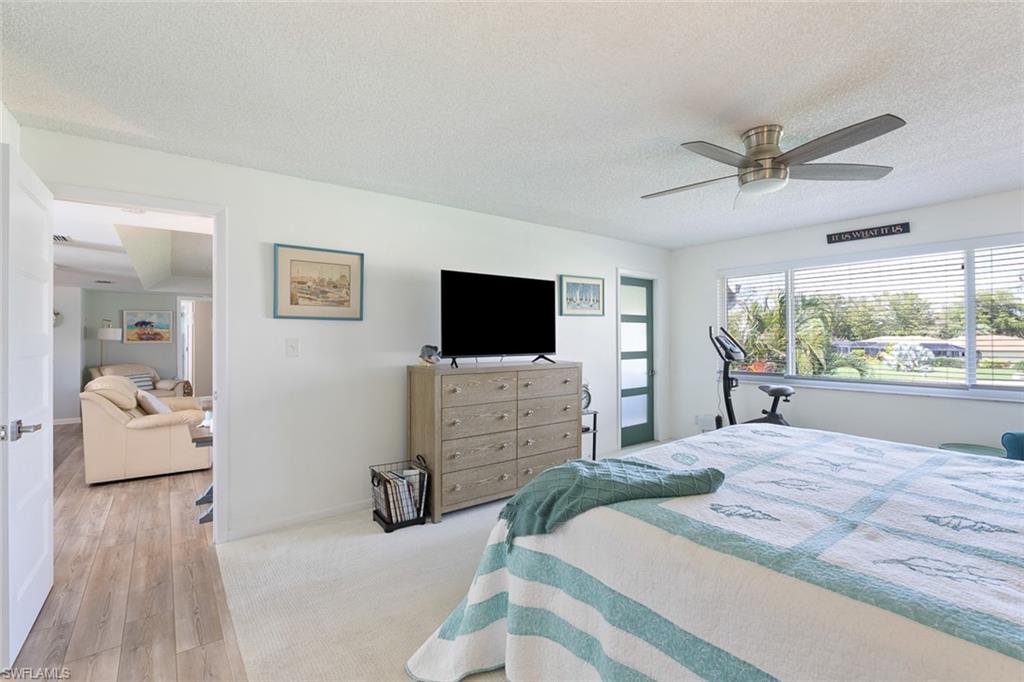 159 Quails Nest Road, Unit 1084 Naples, FL 34112 - Photo 14 of 21 a bedroom with furniture and flat screen tv
