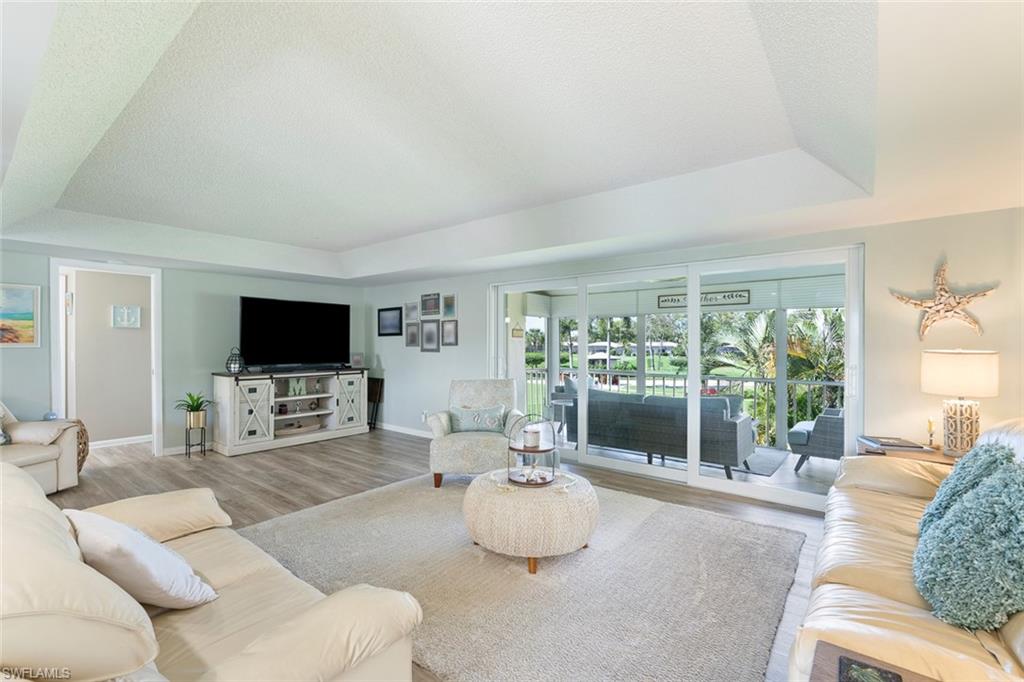 159 Quails Nest Road, Unit 1084 Naples, FL 34112 - Photo 18 of 21 a living room with furniture and a flat screen tv