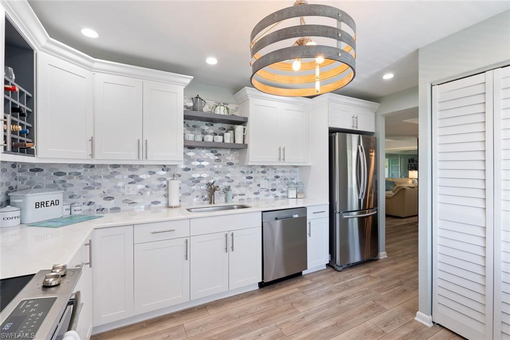 159 Quails Nest Road, Unit 1084 Naples, FL 34112 - Photo 3 of 21 a kitchen with stainless steel appliances granite countertop a sink a stove and a refrigerator