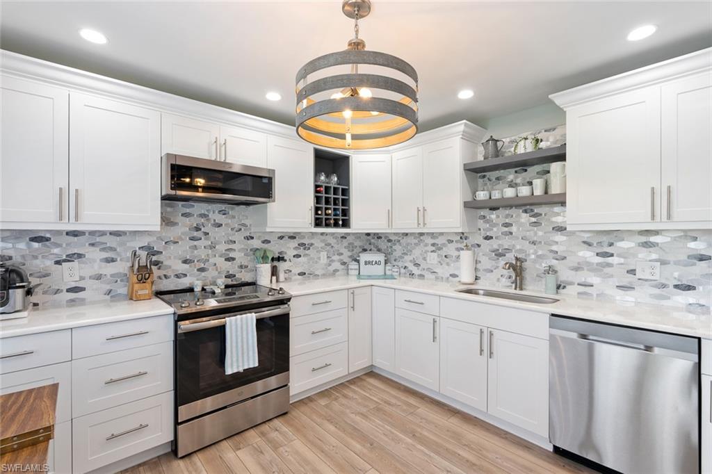 159 Quails Nest Road, Unit 1084 Naples, FL 34112 - Photo 4 of 21 a kitchen with stainless steel appliances granite countertop a sink and cabinets with wooden floor
