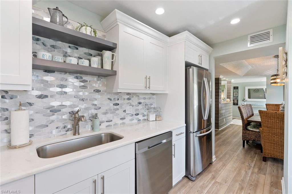159 Quails Nest Road, Unit 1084 Naples, FL 34112 - Photo 7 of 21 a kitchen with stainless steel appliances granite countertop a refrigerator and a sink