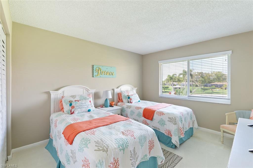 159 Quails Nest Road, Unit 1084 Naples, FL 34112 - Photo 8 of 21 a bedroom with two beds and a large window