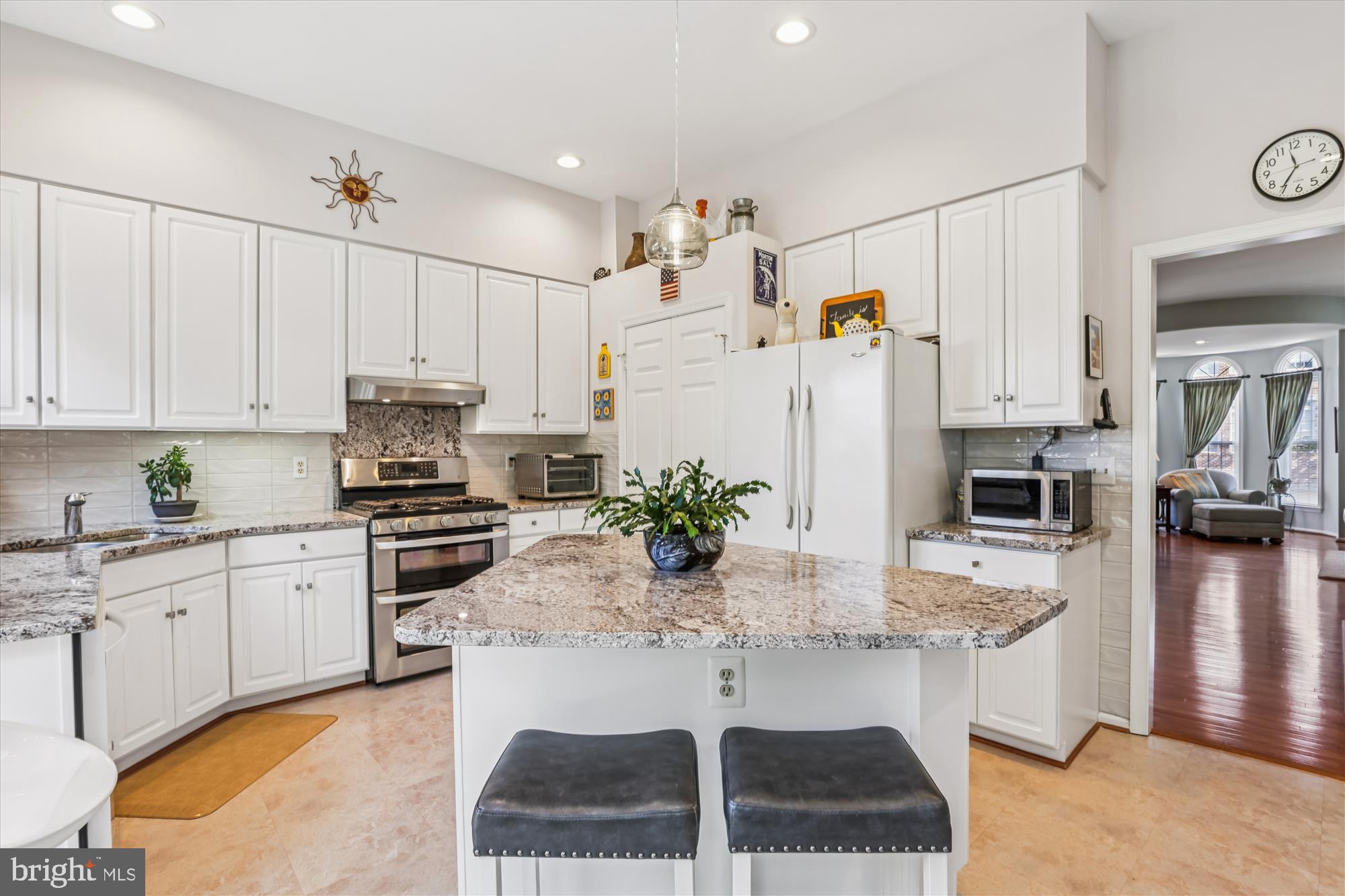 20679 Riptide Square Sterling, VA 20165 - Photo 11 of 43 a kitchen with stainless steel appliances kitchen island granite countertop a table and chairs in it