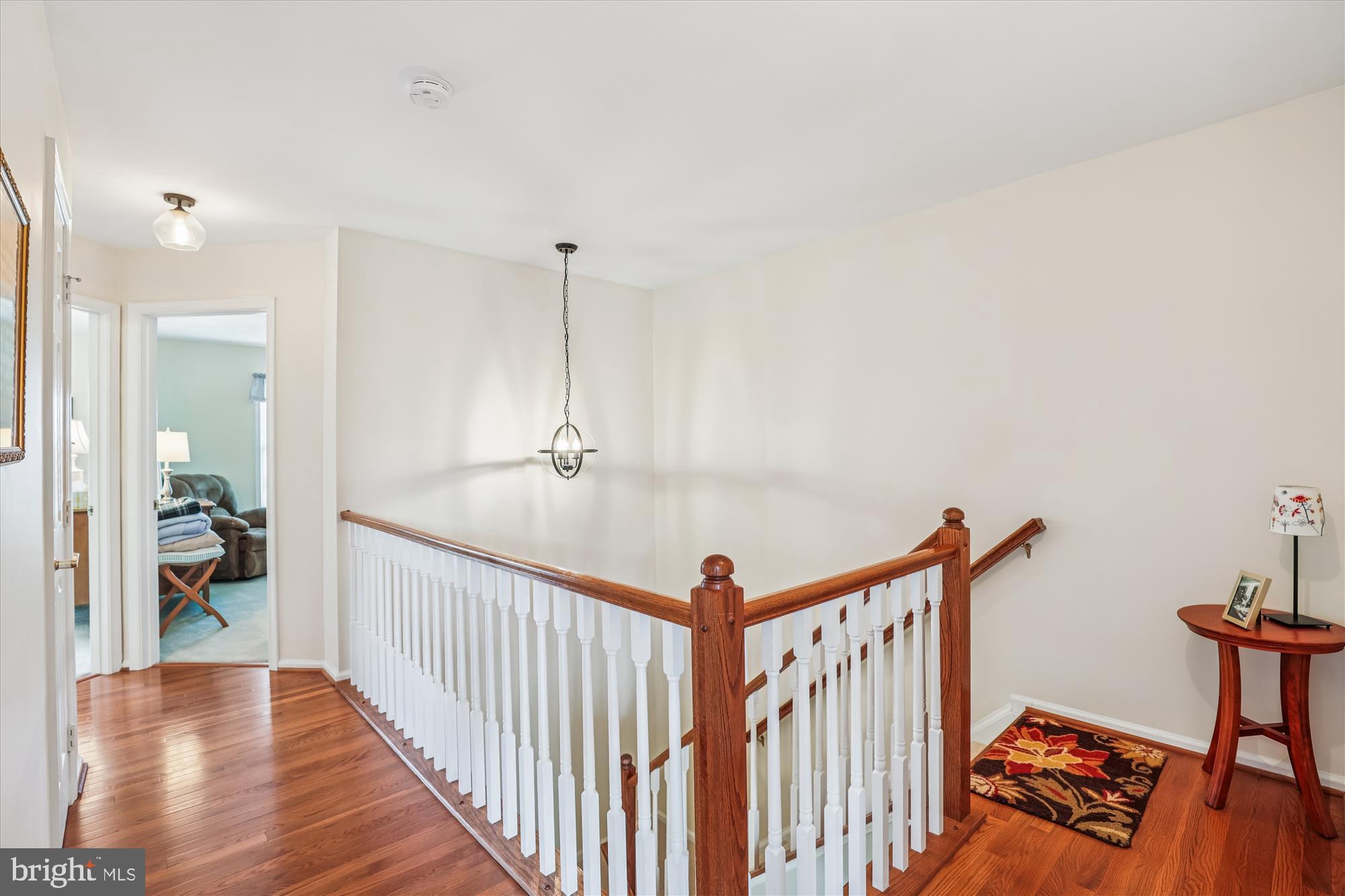 20679 Riptide Square Sterling, VA 20165 - Photo 26 of 43 a view of a hallway to a livingroom with wooden floor and furniture