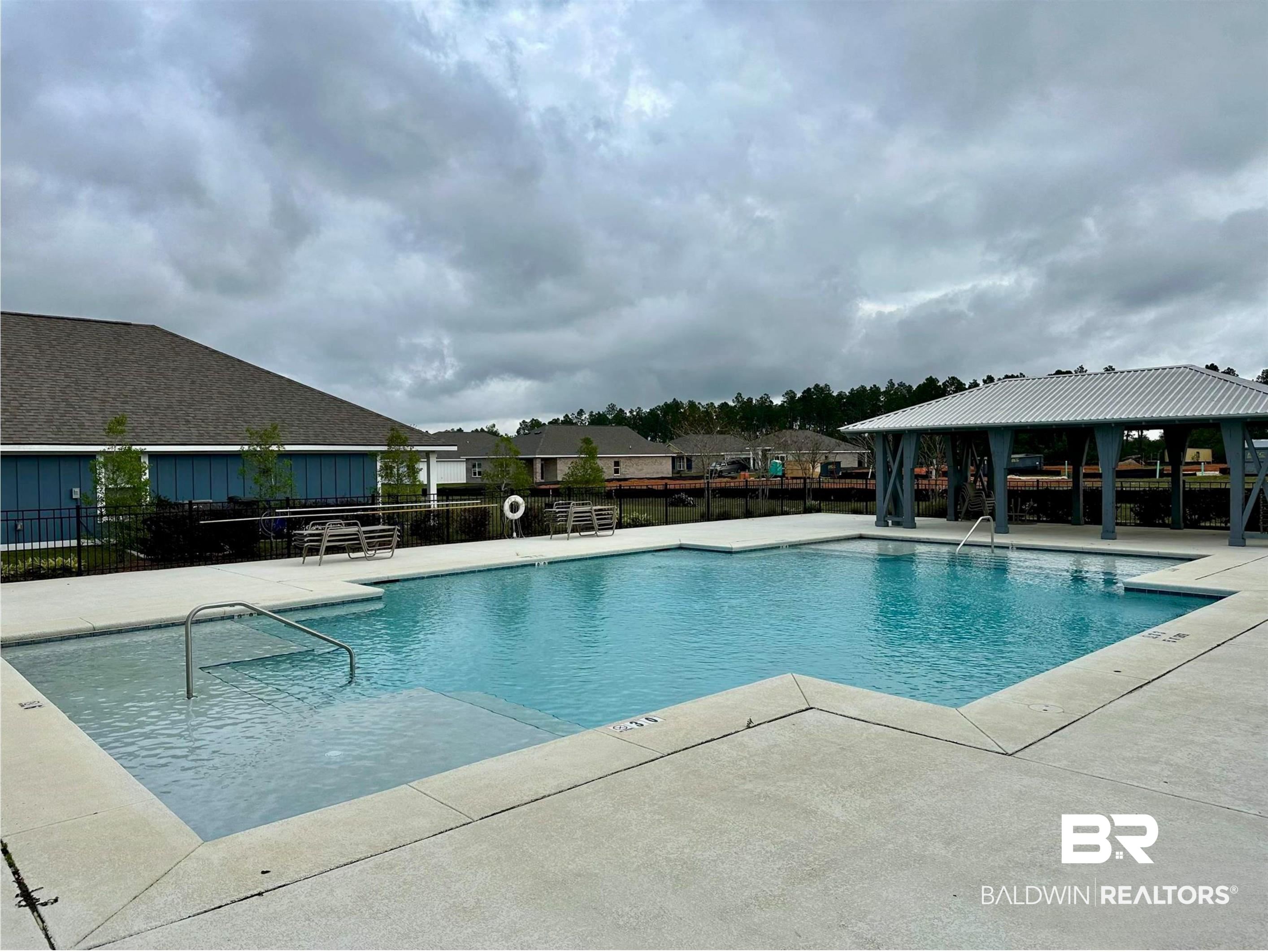 1040 Hayward Loop Foley, AL 36535 - Photo 35 of 35 Expansive swimming pool with integrated shallow entry, surrounded by a concrete deck and a shaded pavilion structure