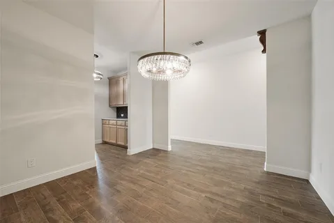 a view of a kitchen with wooden floor and refrigerator