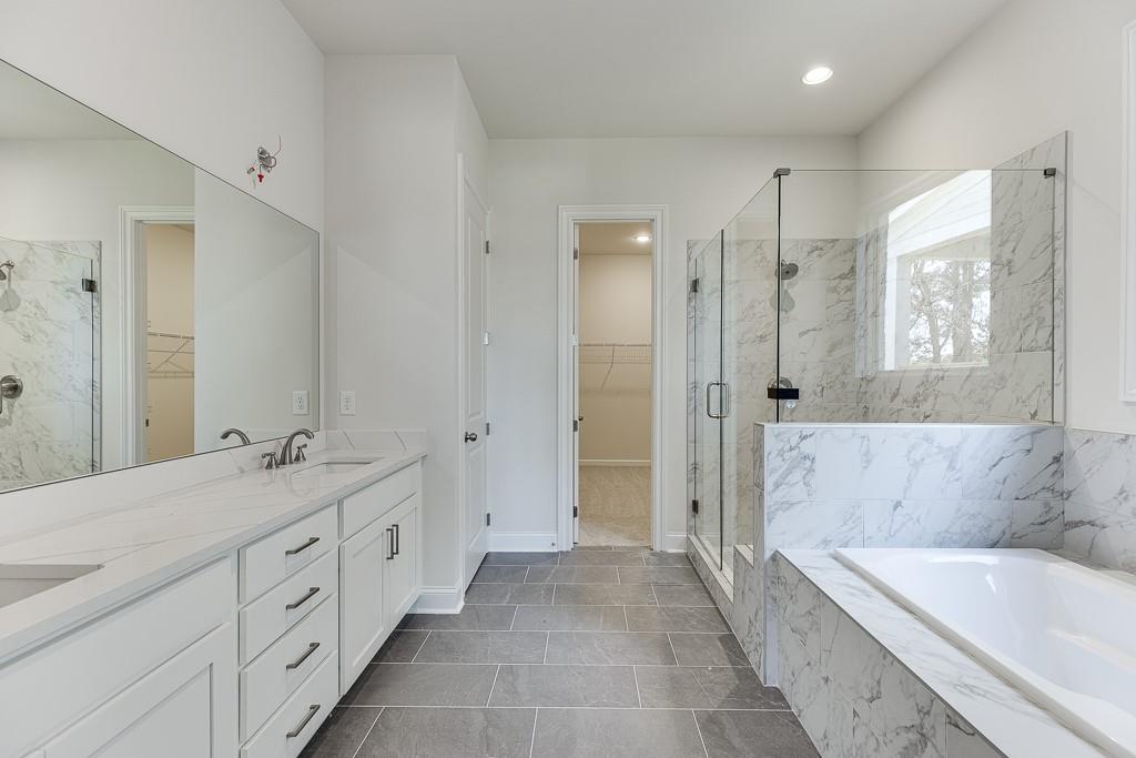 454 Thunder Road Buford, GA 30518 - Photo 29 of 78 a spacious bathroom with a double vanity sink shower and a bathtub