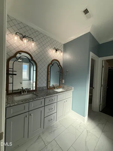 a bathroom with double sink and a mirror