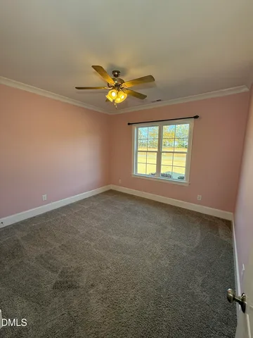 an empty room with a window and a fan