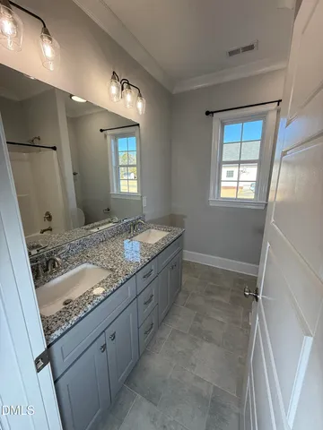 a bathroom with a granite countertop sink a toilet and a mirror