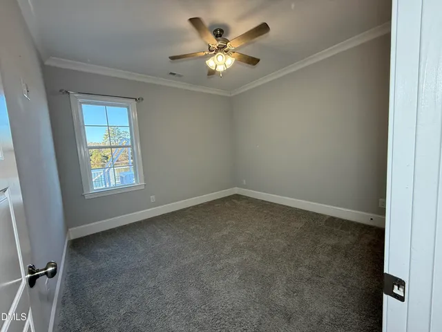 an empty room with a window and a ceiling fan