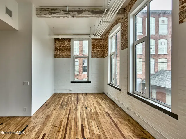 a view of a room with wooden floor and windows