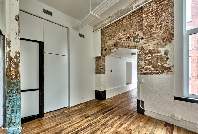 a view of empty room with wooden floor and cabinet