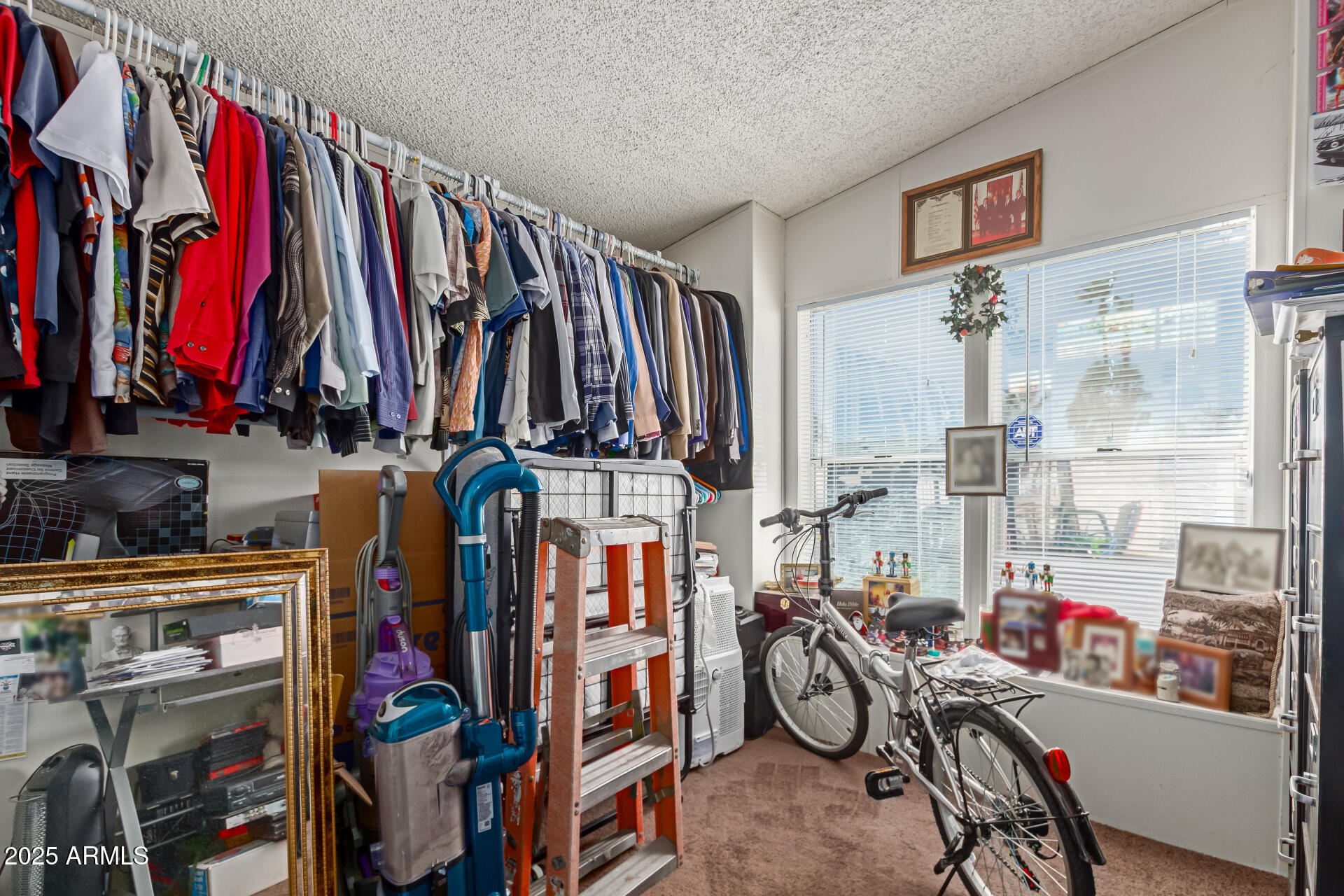 1221 North Dysart Road, Unit 42 Avondale, AZ 85323 - Photo 20 of 23 a view of walk in closet with clothes and shoes