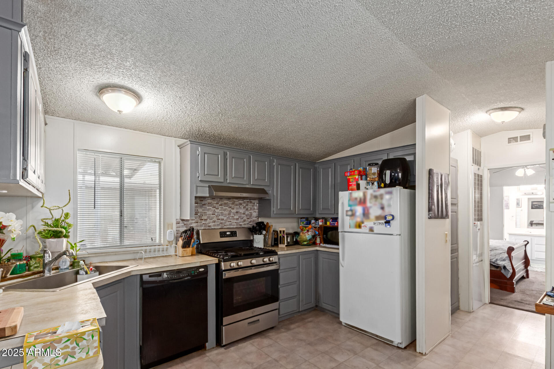 1221 North Dysart Road, Unit 42 Avondale, AZ 85323 - Photo 6 of 23 a kitchen with stainless steel appliances granite countertop a refrigerator stove and sink