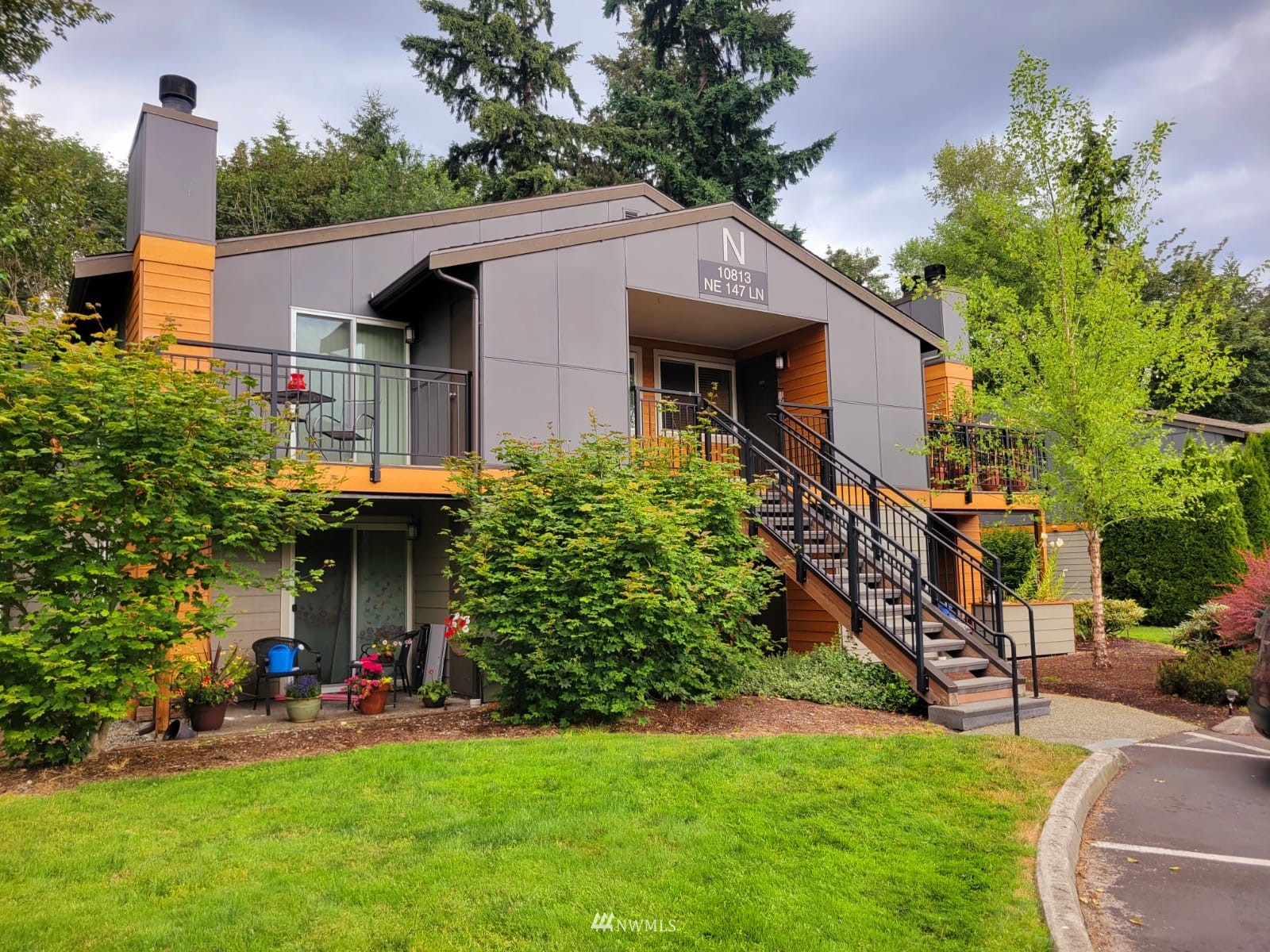 10813 Northeast 147th Lane, Unit N102 Bothell, WA 98011 - Photo 1 of 25 a front view of a house with a yard
