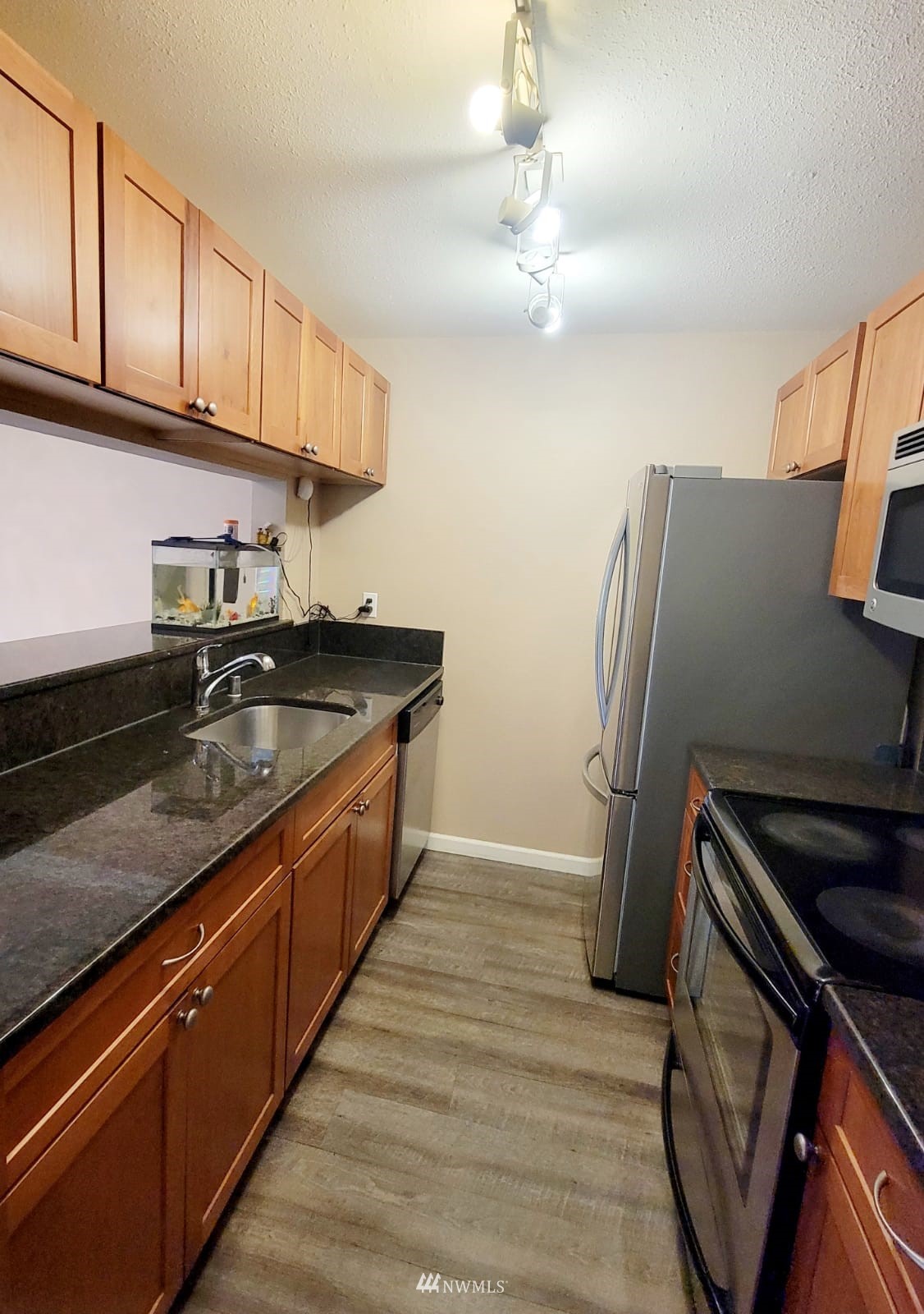 10813 Northeast 147th Lane, Unit N102 Bothell, WA 98011 - Photo 17 of 25 a kitchen with stainless steel appliances granite countertop a sink stove and refrigerator