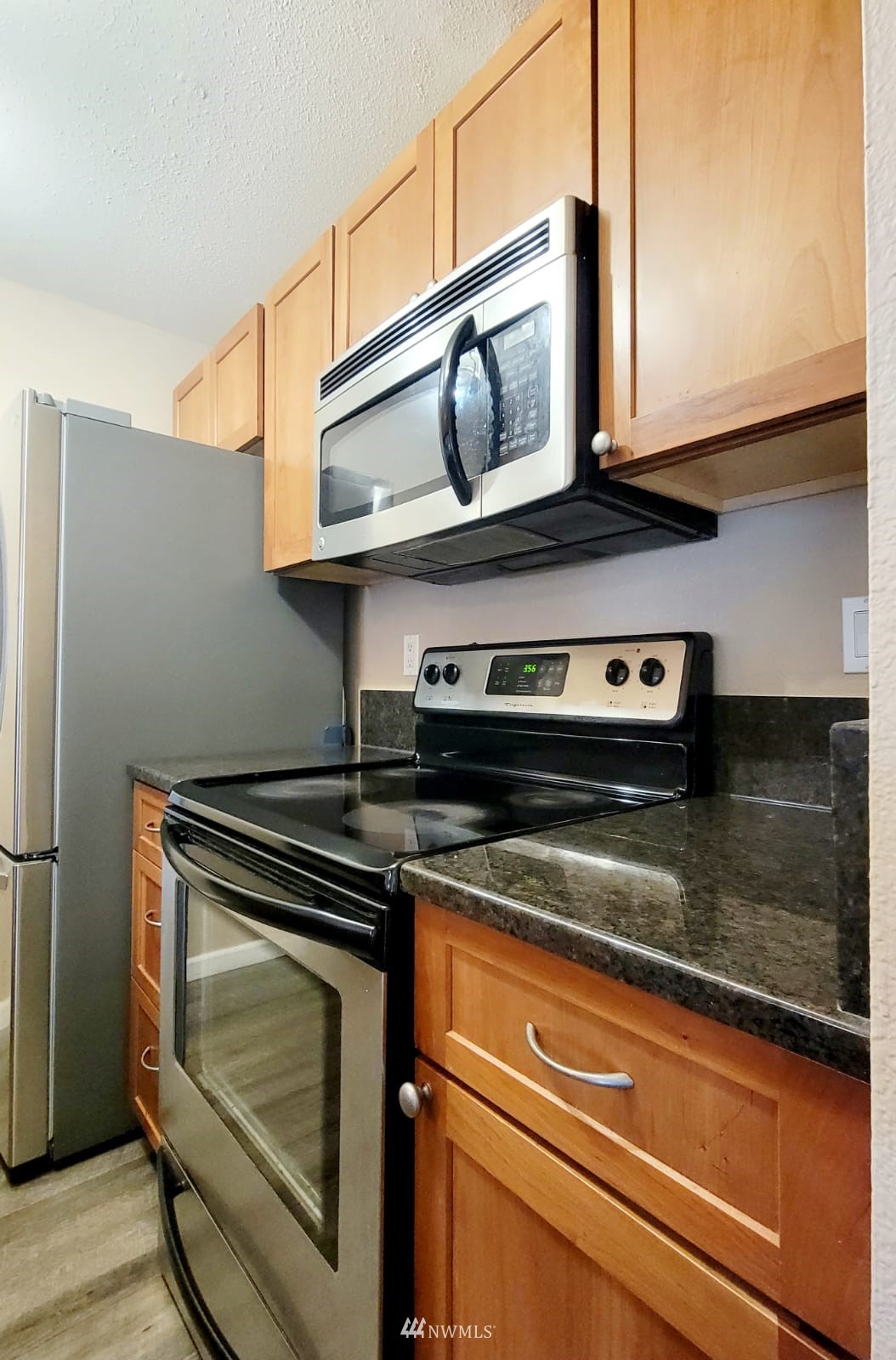 10813 Northeast 147th Lane, Unit N102 Bothell, WA 98011 - Photo 18 of 25 a stove top oven sitting inside of a kitchen