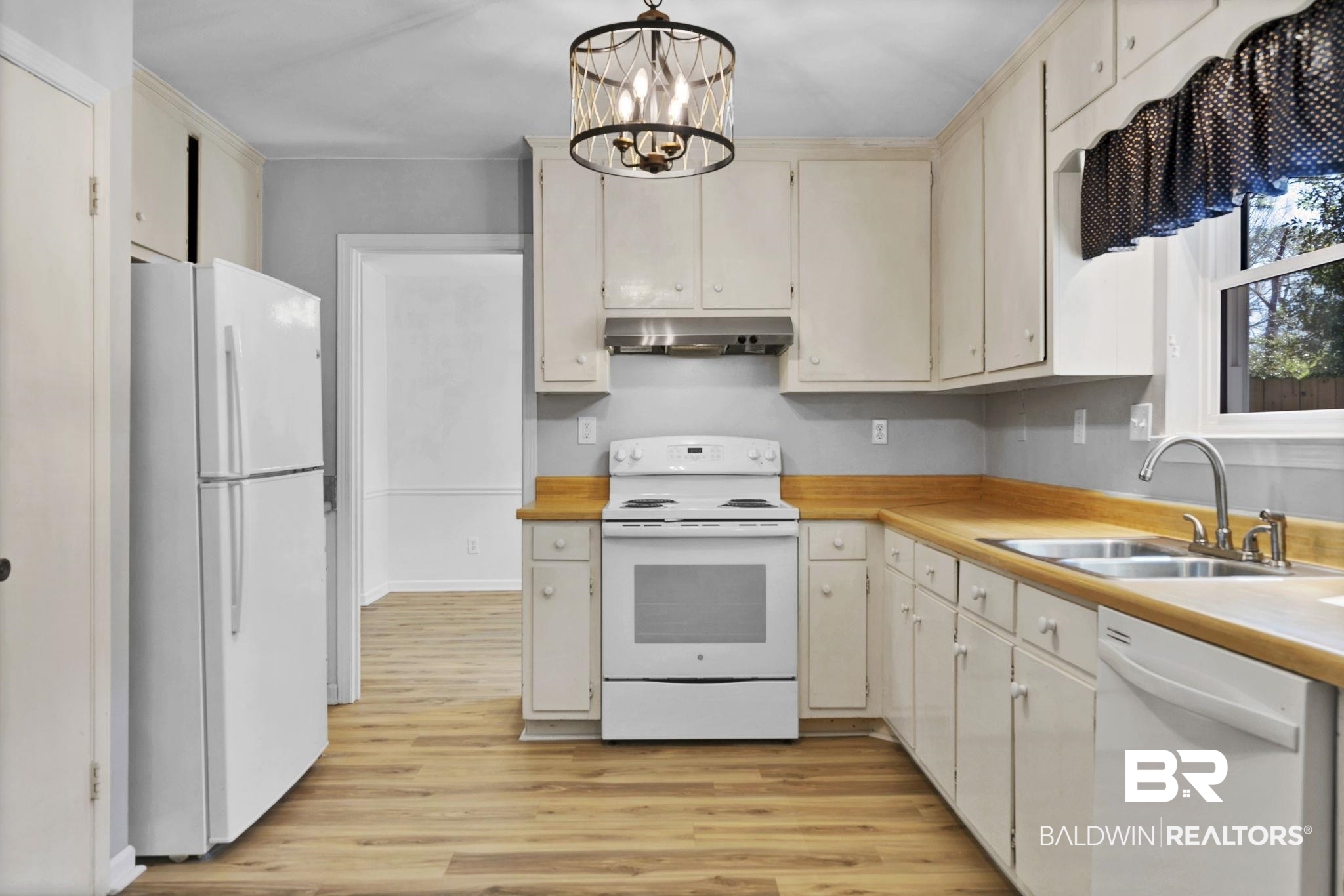 5817 Woodgate Road Mobile, AL 36609 - Photo 24 of 85 Kitchen with white appliances, light countertops, a sink, and under cabinet range hood