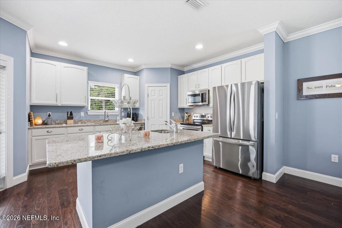 4009 Palm Way Jacksonville Beach, FL 32250 - Photo 6 of 24 a kitchen with stainless steel appliances granite countertop a refrigerator a sink dishwasher a stove and white cabinets with wooden floor