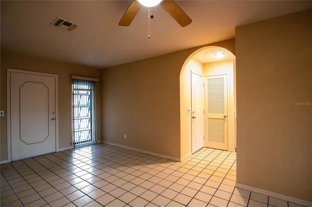 a view of an empty room with window and cabinet