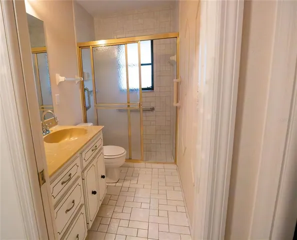 a bathroom with a granite countertop sink toilet and shower