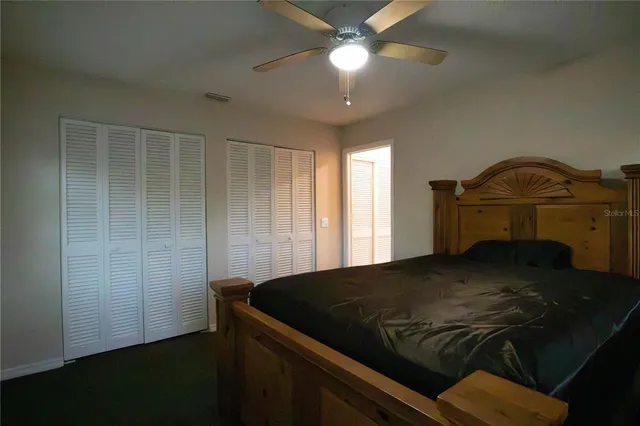 a bed sitting in a bedroom next to a window and a chandelier