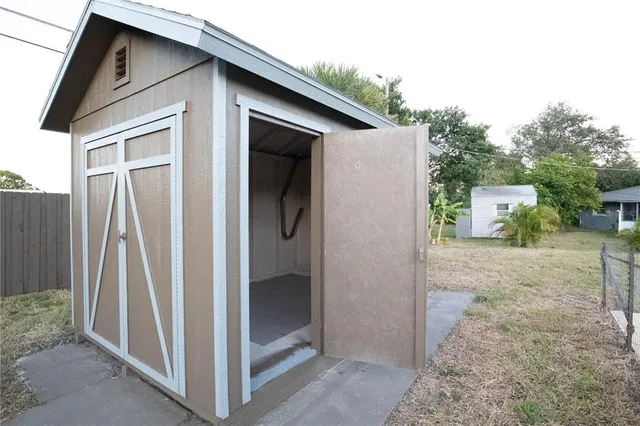 a view of a house with backyard and trees