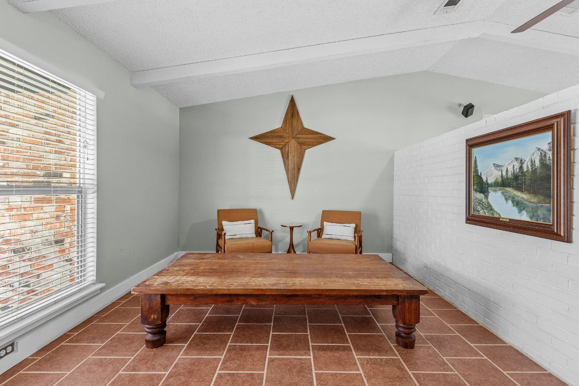 1906 Parkside Lane Austin, TX 78745 - Photo 13 of 40 Sitting room with lofted ceiling, brick wall, a textured ceiling, and ceiling fan