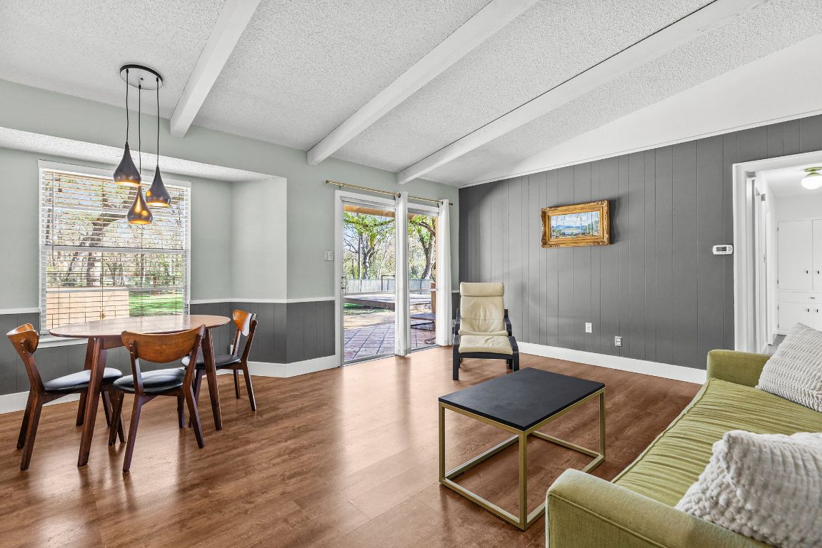 1906 Parkside Lane Austin, TX 78745 - Photo 3 of 40 Living room with wood walls, a textured ceiling, and wood finished floors