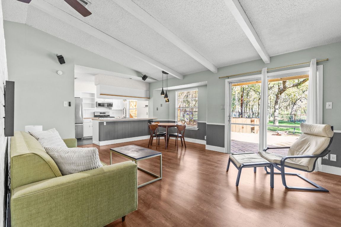 1906 Parkside Lane Austin, TX 78745 - Photo 4 of 40 Living area with a textured ceiling, dark wood-style flooring, a ceiling fan, and a wainscoted wall