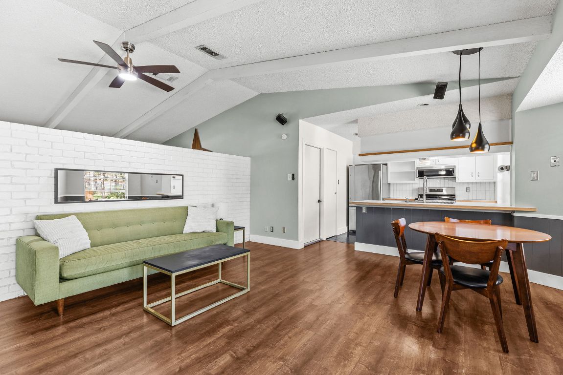 1906 Parkside Lane Austin, TX 78745 - Photo 5 of 40 Living room with dark wood-type flooring, a ceiling fan, brick wall, and a textured ceiling