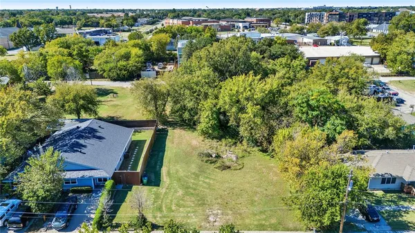 an aerial view of residential houses with outdoor space and trees