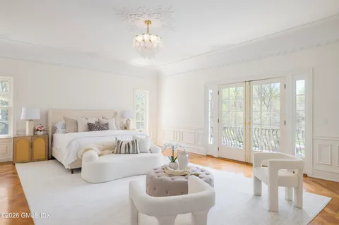 a spacious bedroom with a large bed and a chandelier