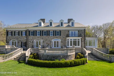 a view of a house with a big yard and sitting area