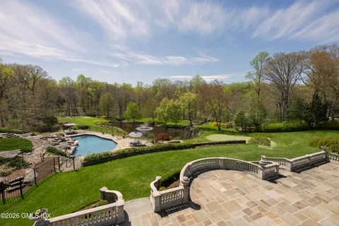 a view of swimming pool with lawn chairs and potted plants