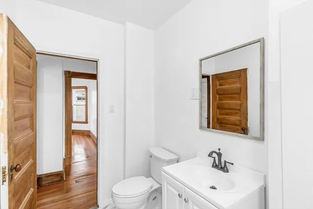 a bathroom with a toilet a sink and mirror