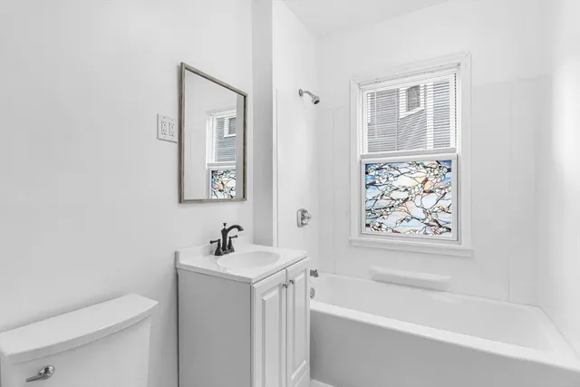 a white bath tub sitting next to a white toilet and a sink