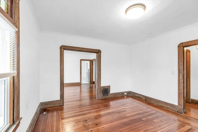 a view of empty room with wooden floor