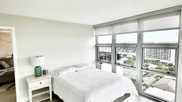 a bedroom with a bed and a large window with outer view