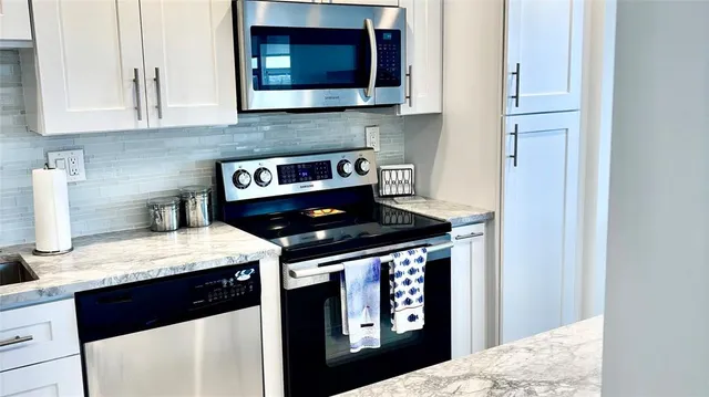 a kitchen with stainless steel appliances granite countertop a stove and a microwave