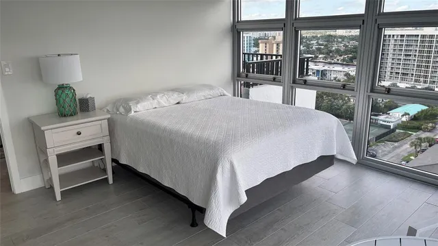 a bedroom with a bed and a large window