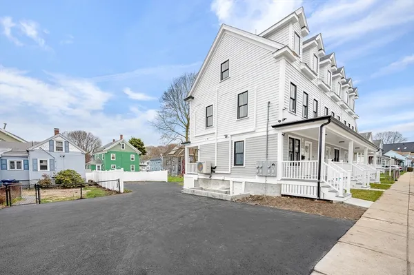 a view of a white house with a street