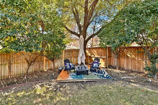 a view of a park with large trees and wooden fence