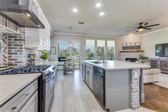 a kitchen with stainless steel appliances granite countertop sink stove and refrigerator