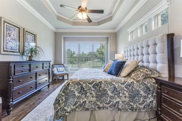 a bed sitting in a bedroom next to a window with a chandelier