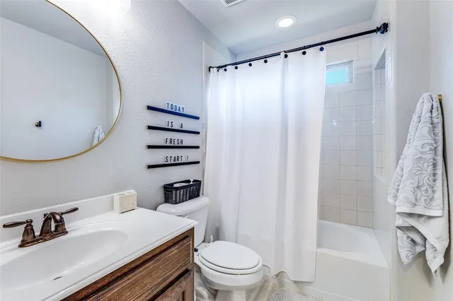 a bathroom with a sink a toilet and shower curtain